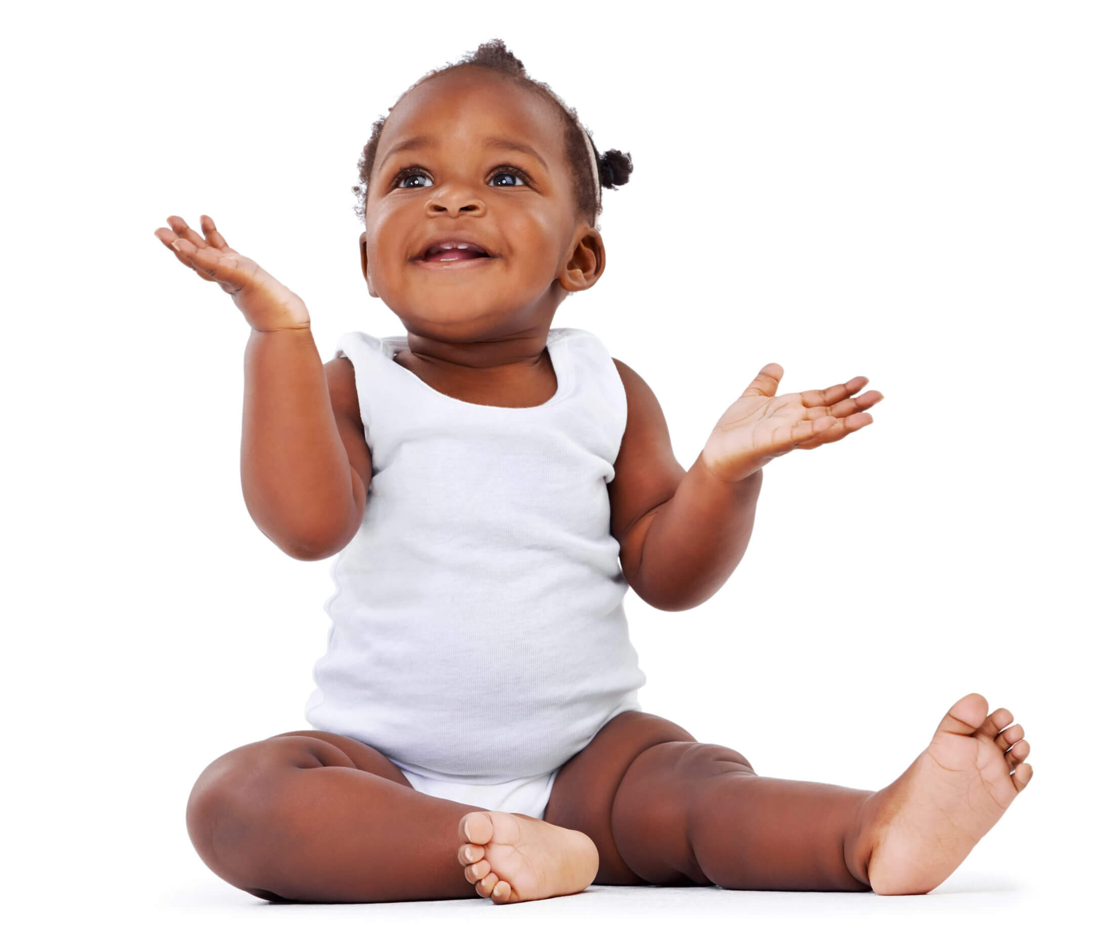 Dark skin toned baby girl wearing a white onesie smiling holding her hands up.